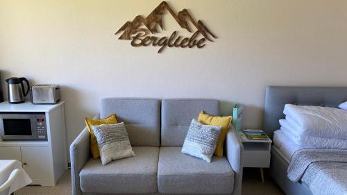a living room with a couch and a sign on the wall at Sofia in Balderschwang