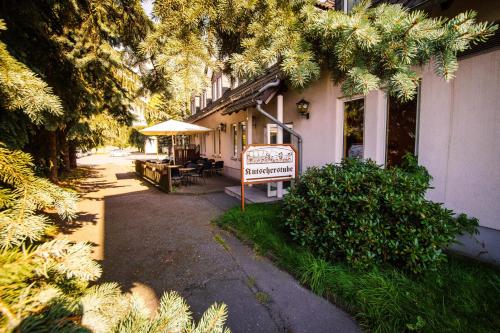 a building with a table and an umbrella on a street at Hotel Gasthof zur Heinzebank in Wolkenstein