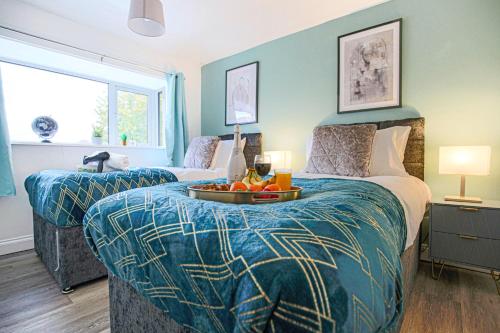 Un dormitorio con 2 camas y una mesa con fruta. en Hornbeam House with Free Parking, Super-Fast WIFI and Smart TV by Yoko Property, en Milton Keynes