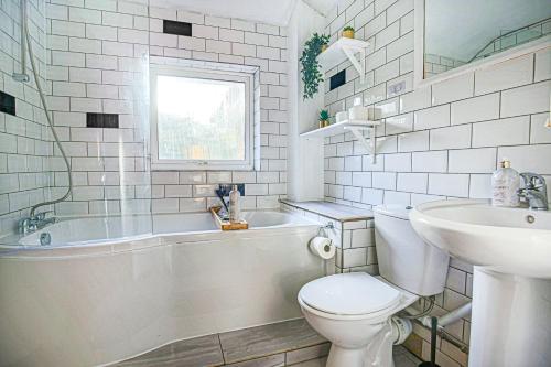 Baño blanco con aseo y lavamanos en Hornbeam House with Free Parking, Super-Fast WIFI and Smart TV by Yoko Property, en Milton Keynes