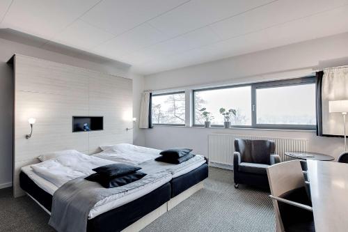 a bedroom with a bed and a desk and a chair at Radisson Blu Hotel i Papirfabrikken, Silkeborg in Silkeborg
