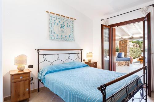 Un dormitorio con una cama y una puerta corrediza de vidrio. en Casa Isabella villa con dependance, en Porto San Paolo