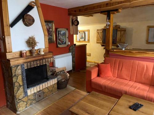 a living room with a red couch and a fireplace at Apartmani Marija in Jahorina