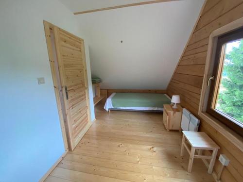 a room with a bed and a door and a window at DOMKI W CHMURACH in Międzylesie