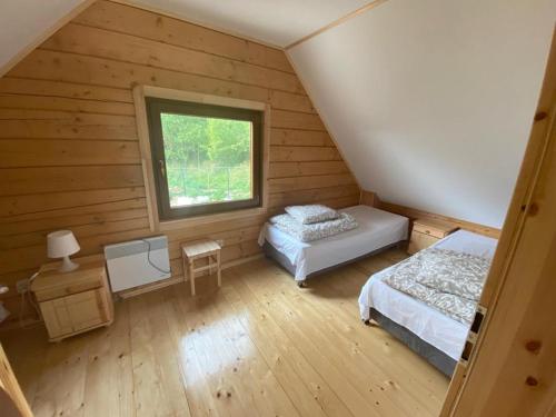 a attic room with two beds and a window at DOMKI W CHMURACH in Międzylesie