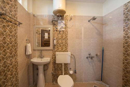 a bathroom with a toilet and a sink and a shower at goSTOPS Mussoorie, Library Road in Mussoorie
