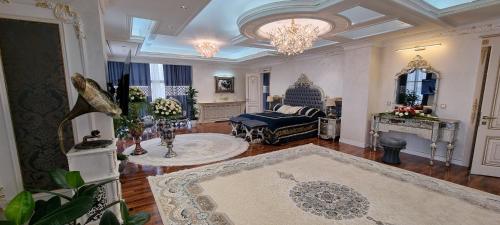 a large living room with a bed and a chandelier at Safo Dushanbe in Dushanbe