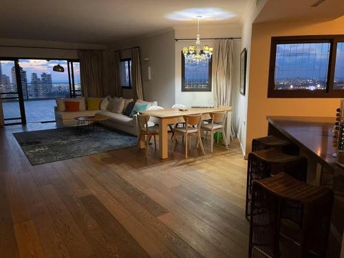 a kitchen and living room with a table and a couch at Beautiful Penthouse w/amazing View, Prime location in Ramat Gan