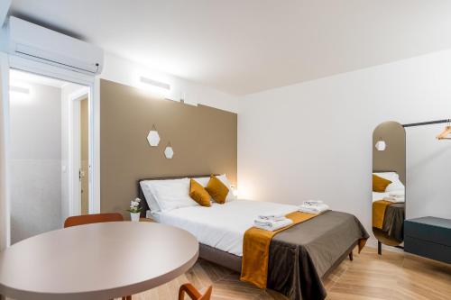 a hotel room with a bed and a table at DOMO Premium Apartments - Trieste Mazzini in Trieste