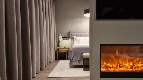 a bedroom with a fireplace in front of a bed at DS Hotel Lusopark in Santa Maria da Feira