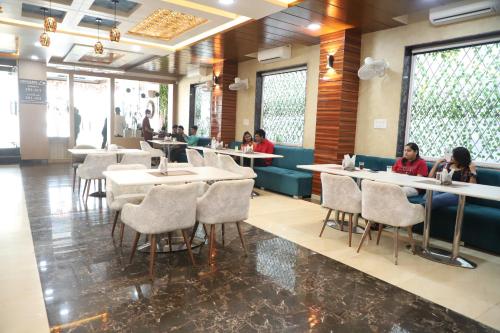 jadalnia z ludźmi siedzącymi przy stołach w obiekcie SRG INN HOTEL w mieście Bharatpur