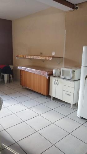 a kitchen with a counter and a microwave in it at Hotel Brasil in Presidente Prudente
