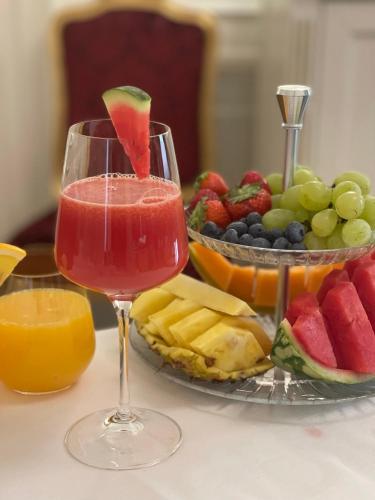 a drink in a glass next to a plate of fruit at Palazzo Monga Boutique Guesthouse in Verona