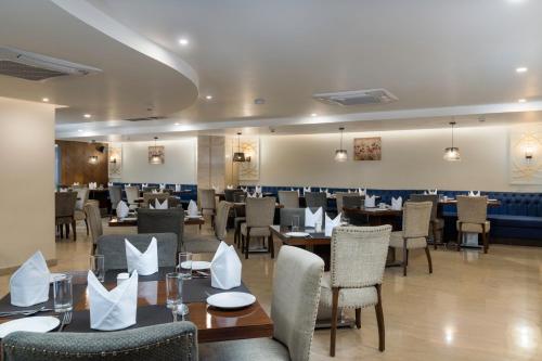a dining room with tables and chairs in a restaurant at Cygnett Inn Paras in Dehradun