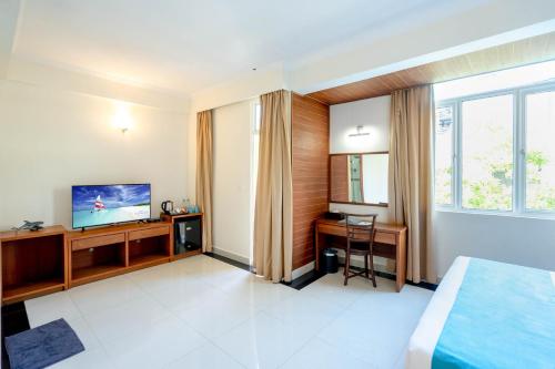 a hotel room with a bed and a television at Noomoo Hulhumale in Hulhumale