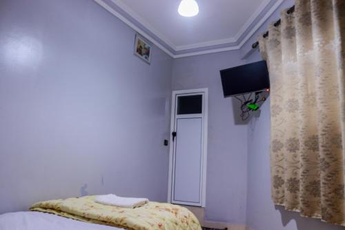 um quarto com uma cama e uma televisão na parede em Hotel Palace Zaida em Zeïda