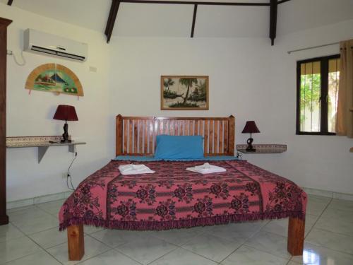 a bedroom with a bed with a red bedspread at ALONALAND RESORT in Panglao Island