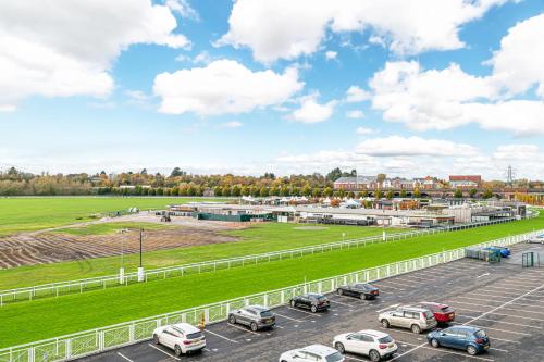 a parking lot with cars parked in front of a race track at The POPULAR Chester Racecourse Apartments, Sleeps 4, FREE Parking in Chester