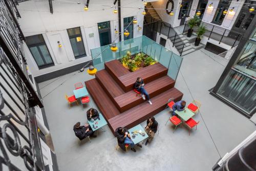 a group of people sitting at tables in a building at a&o Budapest City in Budapest