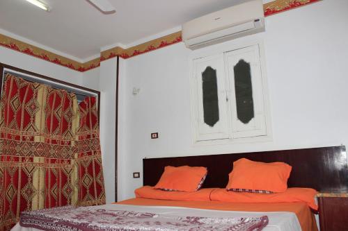 a bedroom with a bed with orange pillows at Nuba Dool in Aswan