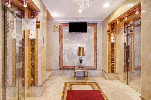 a hallway with a television and a red rug at OYO 588 Shoab Jeddah Suites in Jeddah