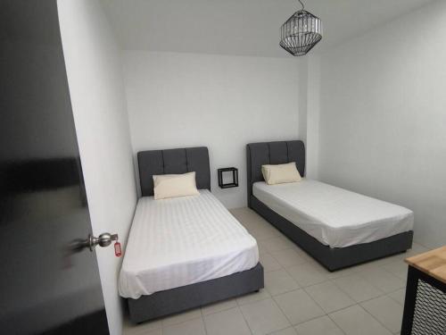 2 camas en una habitación con puerta abierta en MODERN , SPACIOUS GAMBANG UMP 18 Guest House en Gambang