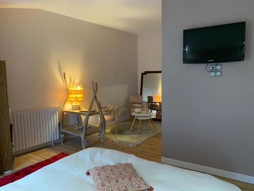 a bedroom with a bed and a tv on a wall at Gîte Orget in Saint-Macaire
