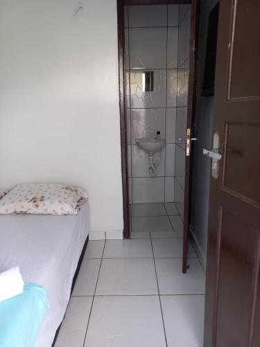 a bathroom with a bed and a sink and a shower at HOTEL LATINOS 2 in Boa Vista