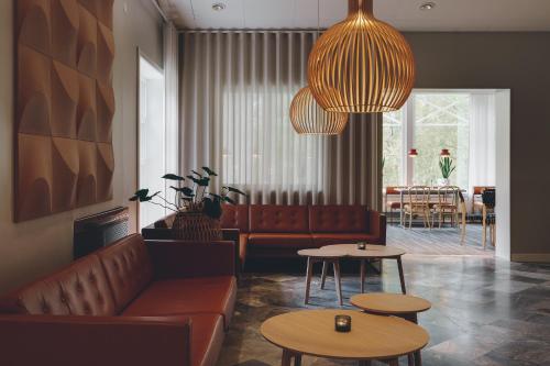 a living room with a couch and two tables at Medlefors Hotell & Konferens in Skellefteå