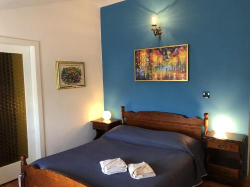 a blue bedroom with a bed with two towels on it at Family Rooms Sabrina in Poreč