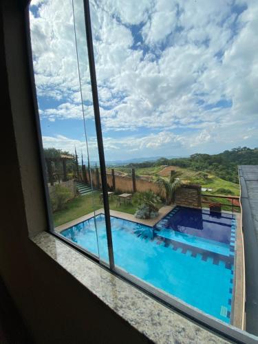 a view of a swimming pool from a window at Pousada Recanto Querubins in Paty do Alferes