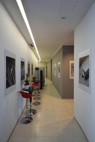 a hallway with stools and paintings on the walls at Hotel Mantova Residence in Mantova