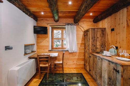 eine Küche mit einem Tisch und einer Badewanne in einer Hütte in der Unterkunft L'Escola e Lou Mulin in Sampeire