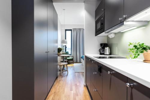 a kitchen with gray cabinets and a white counter top at Biz Apartment Bromma in Stockholm