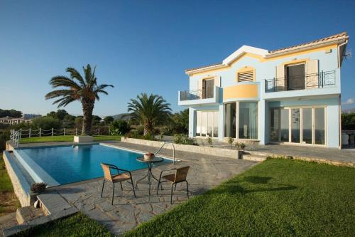 a villa with a swimming pool and a house at Ionian Blue Luxury Villas in Svoronata