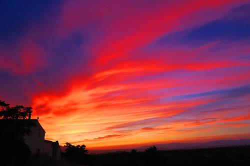 a sunset with red clouds in the sky at Cortijo Paraiso in Cúllar de Baza