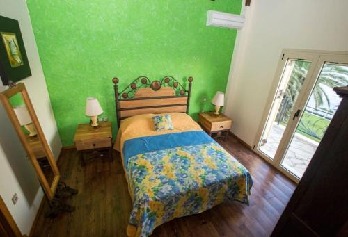 a bedroom with a bed with a green wall at Ionian Blue Luxury Villas in Svoronata
