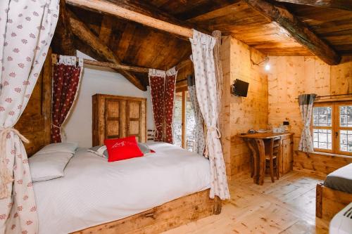 a bedroom with a bed in a room with wooden ceilings at L'Escola e Lou Mulin in Sampeyre