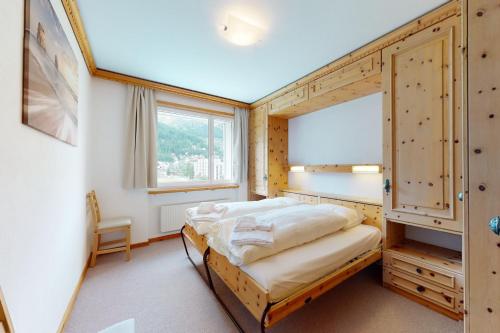 Schlafzimmer mit einem Bett und einem Fenster in der Unterkunft Apartment Ova Cotschna 301 in St. Moritz