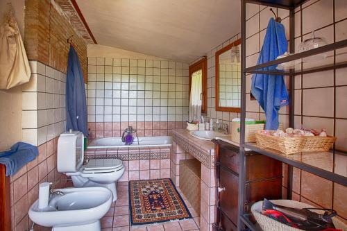 ein Badezimmer mit 2 WCs, einem Waschbecken und einer Badewanne in der Unterkunft Domus Vini in San Giovanni la Punta
