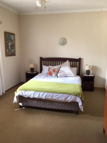 a bedroom with a bed with a green blanket at Bloekomhuis in Smithfield