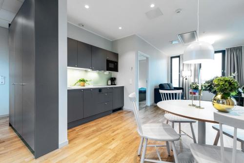 a kitchen and dining room with a table and chairs at Biz Apartment Bromma in Stockholm