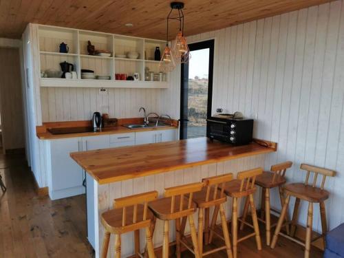 a kitchen with a counter and some stools in it at Cómoda Casa en la Playa in Guaquen