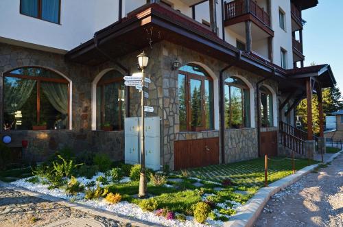 a building with a street sign in front of it at Hotel Iva & Elena in Pamporovo