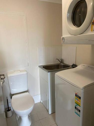a small bathroom with a toilet and a sink at RIVERSIDE CITY VIEW PARKING NETFLIX WIFI WINE FREE in Perth