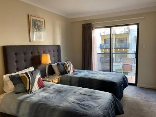 a hotel room with two beds and a window at RIVERSIDE CITY VIEW PARKING NETFLIX WIFI WINE FREE in Perth