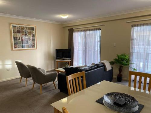 a living room with a couch and a table at RIVERSIDE CITY VIEW PARKING NETFLIX WIFI WINE FREE in Perth