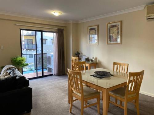 a living room with a table and chairs and a couch at RIVERSIDE CITY VIEW PARKING NETFLIX WIFI WINE FREE in Perth