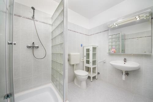 y baño con aseo, lavabo y ducha. en Familia apartman 100/2, en Balatonmáriafürdő