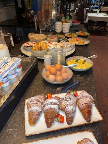 a buffet with plates of food on a table at Hotel De Kalvaar in Ninove